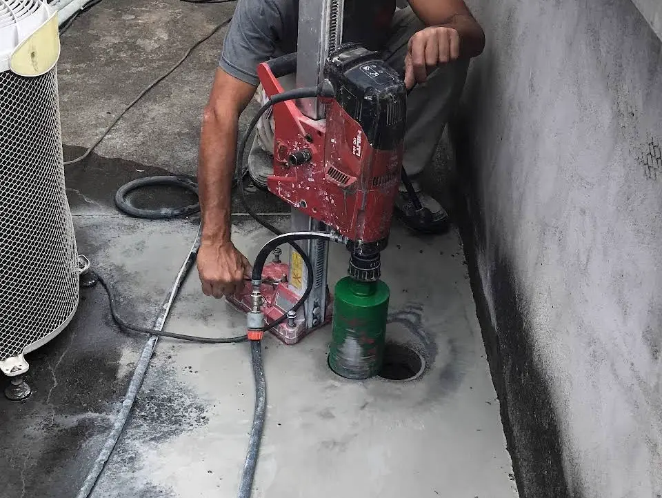 Perfuração de piso de concreto com equipamento profissional